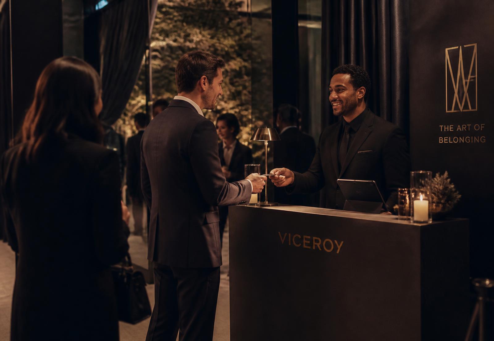 A host welcoming guests at an elegant evening event reception desk